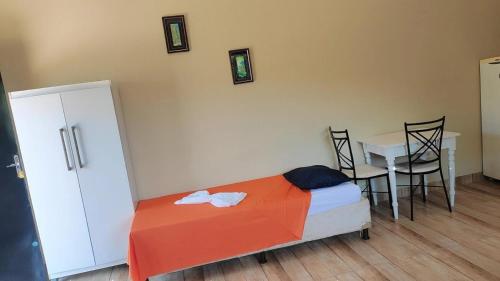 阿普卡拉纳Pousada Apucarana - Sede的卧室配有一张床和一张桌子及椅子