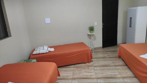 阿普卡拉纳Pousada Apucarana - Sede的一间设有两个橙色桌子和黑色门的房间