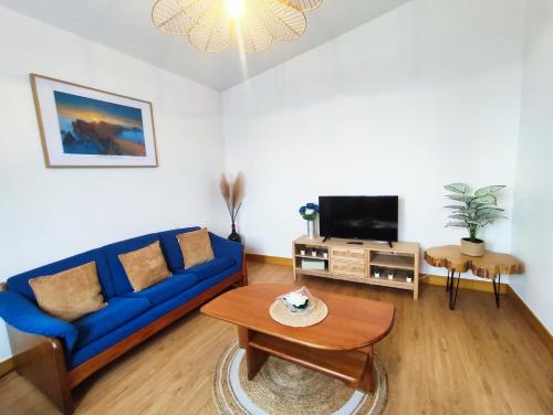 马希库GATEONE AL Airport View House的客厅配有蓝色的沙发和电视