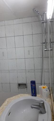 迪拜Bed Space Hostel的白色瓷砖浴室设有水槽和淋浴