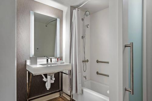 奥兰多奥兰多市中心喜来登酒店的白色的浴室设有水槽和淋浴。