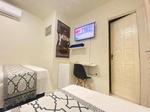 大坎皮纳Pousada Açude Velho的客房设有两张床、一扇门和电视。