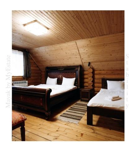 米库利钦Mayak Chalet Resort Mykulychyn的小木屋内一间卧室,配有两张床