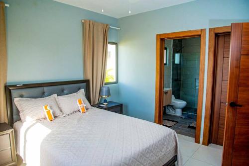 蓬塔卡纳Beautiful Village 3 bedrooms Furnished Pool residencial Velero punta cana的一间卧室配有一张床,浴室设有淋浴。