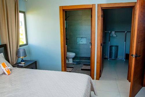 蓬塔卡纳Beautiful Village 3 bedrooms Furnished Pool residencial Velero punta cana的一间卧室配有一张床,浴室设有卫生间