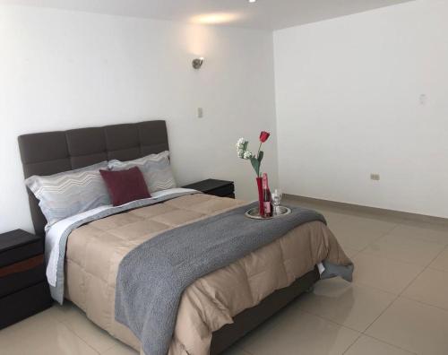卡哈马卡HOTEL CB CAJAMARCA HUACARIZ的一间卧室配有一张带鲜花桌的床