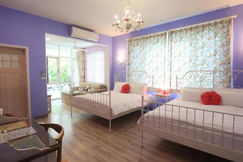 吉安干城小鎮民宿-包棟-寵物友善的一间带两张床的卧室和一间带紫色墙壁的房间
