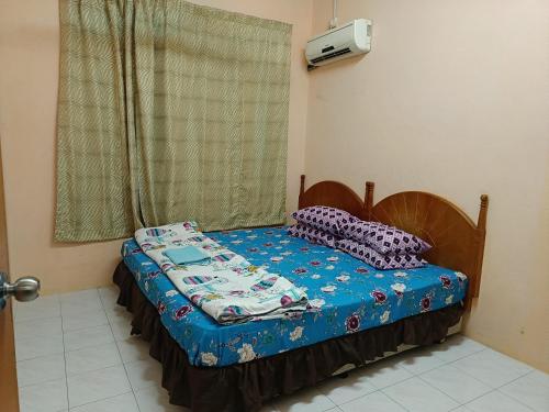 日得拉Homestay Tengku Maheran的窗户客房内的小床