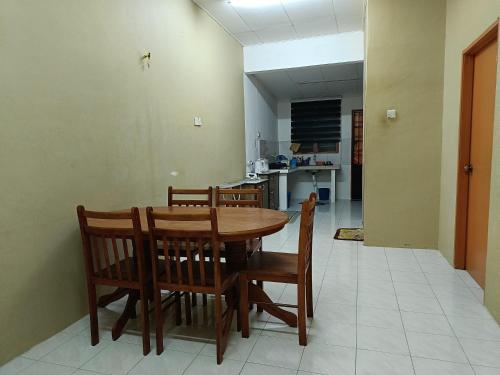 日得拉Homestay Tengku Maheran的一间带木桌和椅子的用餐室