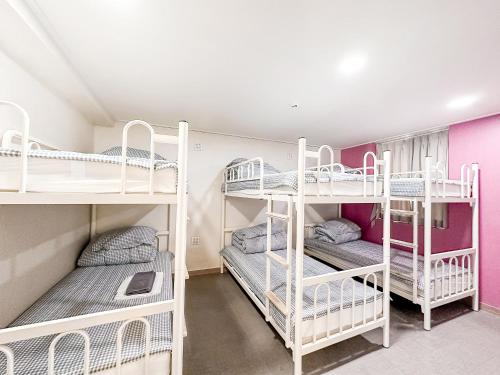 大邱Dongseongro ZERO guesthouse的一间房间,设有三张双层床
