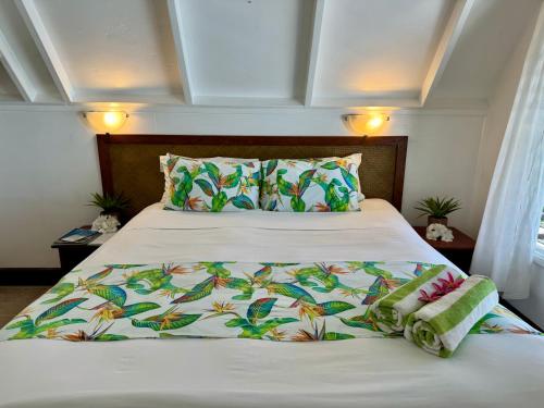 阿鲁坦加帕拉蒂斯湾旅舍的一张带白色棉被和两个枕头的床