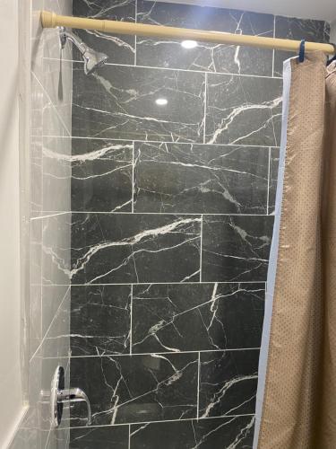纽瓦克Cozy Getaway Room的带淋浴的浴室和黑色石墙