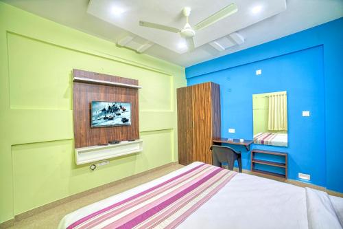 耶拉汉卡RedKEY Inn Bangalore Airport的一间卧室拥有蓝色和绿色的墙壁,配有一张床