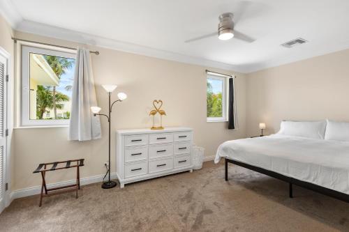Creek VillageParadise Six的卧室配有白色的床和2扇窗户。