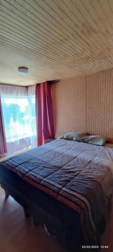 延基韦Casa LLanquihue的一间卧室配有一张带红色窗帘的大床