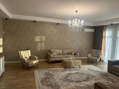 马达肯Дом у моря Мардакане的客厅配有沙发、椅子和吊灯
