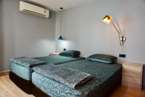 曼谷Chill apartment with unique design @ Silom Soi 3的一间卧室配有两张床和风扇