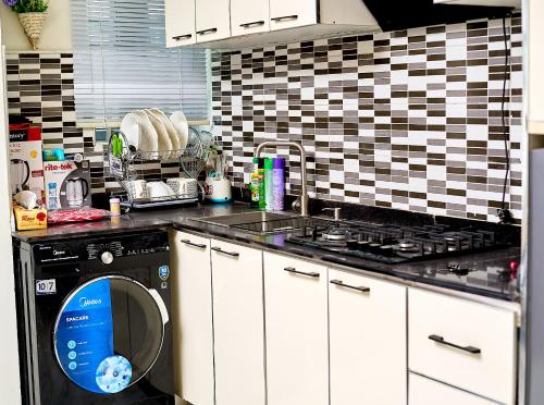 哈科特港Apartment B16的厨房配有洗碗机、水槽和炉灶。