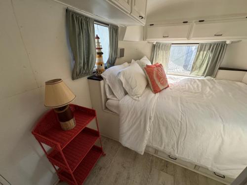帕姆港Vintage Airstream with Hot Tub的一间小卧室,配有白色的床和窗户