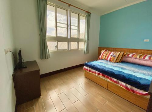 奋起湖阿里山茂馨民宿的一间卧室设有一张床和一个窗口