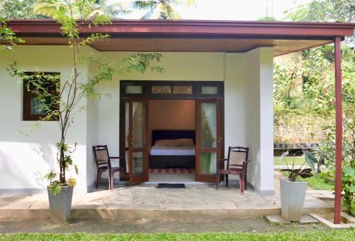 康提The Bliss Hostel Kandy的配有一张床和两把椅子的旅馆