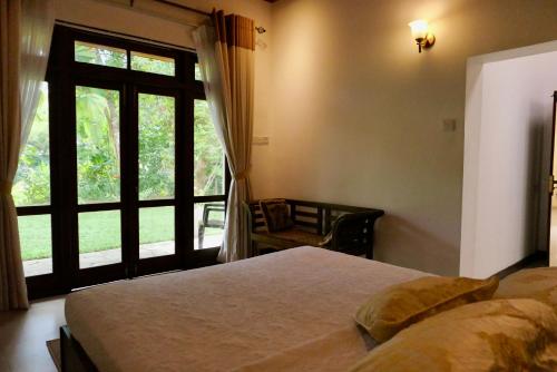 康提The Bliss Hostel Kandy的一间卧室设有一张床和一个大窗户
