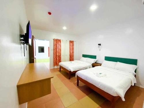 BacongKakisa ll Diving Resort的一间设有两张床和一张桌子的房间