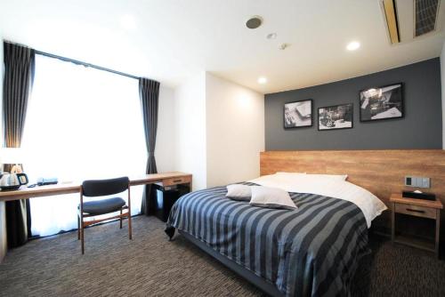 坂井市九重福井酒店的酒店客房配有一张床、一张书桌和一张书桌。