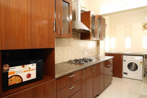 埃尔讷古勒姆Best Serviced Apartments in Cochin Marine drive的一间带木制橱柜和微波炉的厨房