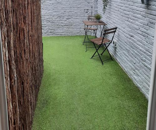 瓦伦西亚Bonito Alojamiento F的一个带绿草和两把椅子及桌子的庭院