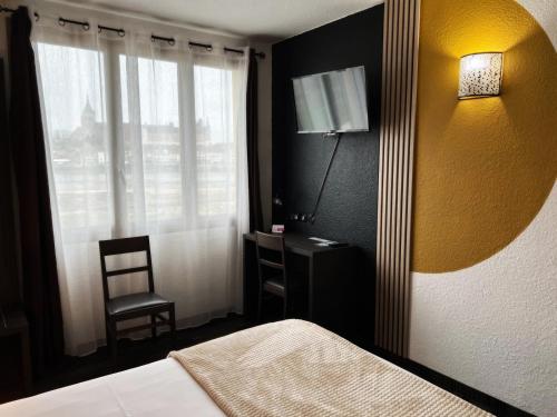 日安Brit Hotel Confort Gien的一间卧室配有一张床、一盏灯和一把椅子