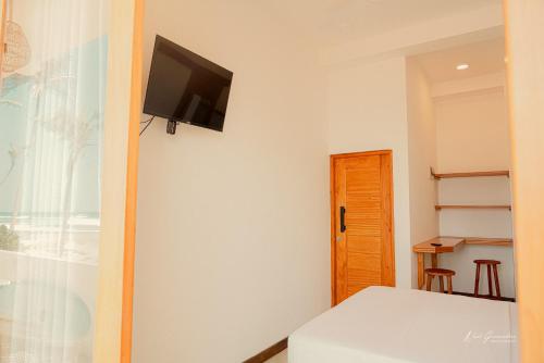 阿杭格默HotelNuvin AHANGAMA的一间卧室配有一张床,墙上配有电视