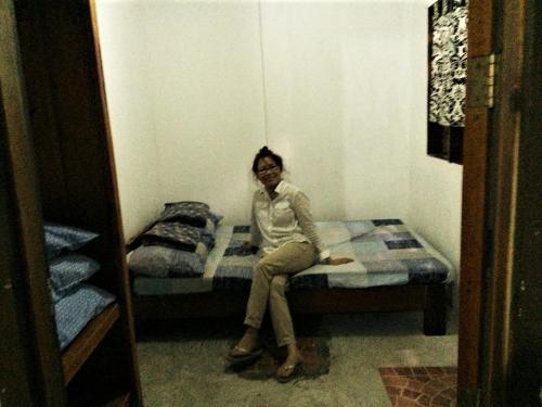 爱妮岛SHALOM CAMP的坐在房间里床边的女人
