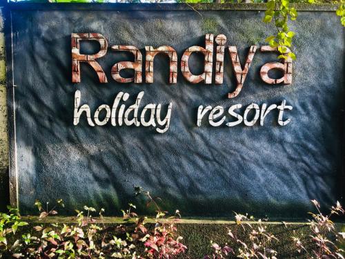 明内里耶Randiya Holiday Resort的墙上的快乐度假的标志