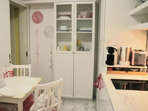 拉韦诺-蒙贝洛ViLLETTA CLAUDETTA的厨房里的白色橱柜,配有桌子