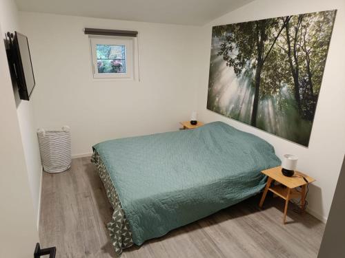 马斯梅赫伦Gusta的卧室配有一张床,墙上挂有绘画作品