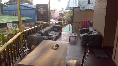 达叻府Crazy Monkey的阳台配有沙发和桌椅。