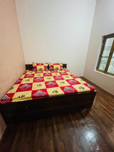 AyodhyaAshu Homestay的一间卧室配有一张带五颜六色棉被的床
