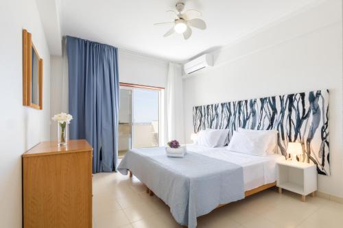 珀彻斯Casa Azul 3 - Senhora da Rocha, Algarve的一间卧室设有一张床和一个大窗户