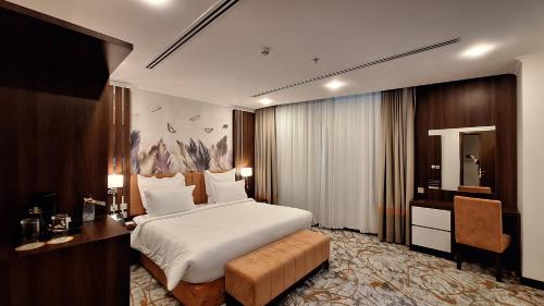哈费尔巴廷Tulip Plaza Hotel的酒店客房配有一张床、一张书桌和一张书桌。