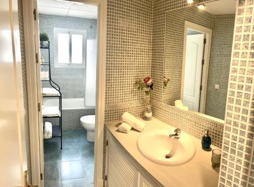 博尔穆霍斯Apartamento Liru Bormujos 2, a 5 minutos de Sevilla的一间带水槽、卫生间和镜子的浴室