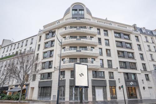 巴黎Yuna Porte-Maillot - ApartHotel的前面有标志的白色建筑