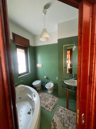 QuattromiglioCASA ZANON的绿色浴室设有浴缸和水槽