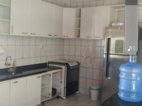 伊列乌斯Marthiane的厨房配有白色橱柜和冰箱。