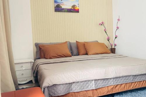 伊洛伊洛WV2 Condotel Luxury的一间卧室配有带橙色和灰色枕头的床
