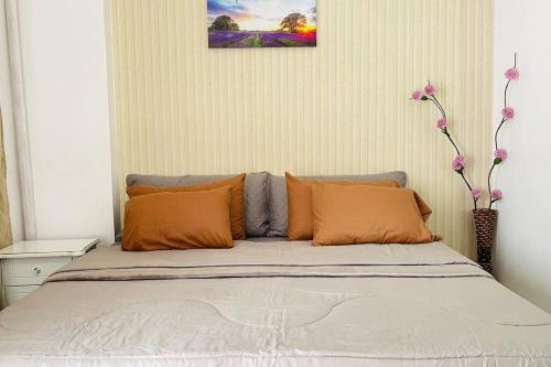 伊洛伊洛WV2 Condotel Luxury的卧室内的一张带橙色枕头的床