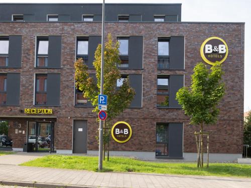 基尔B&B Hotel Kiel-Wissenschaftspark的前面有两个停车标志的砖砌建筑