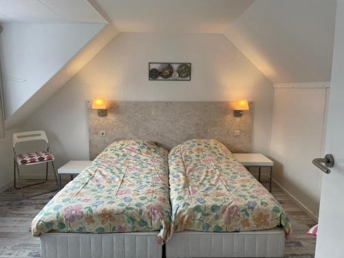 海边的艾格蒙特De Linden的一张位于带两张桌子的小房间的床