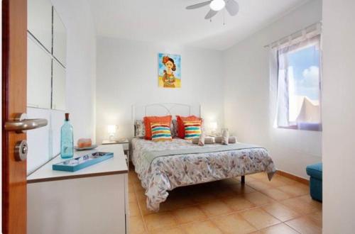 拉奥利瓦Villa Amistad的一间卧室配有一张床、一张桌子和一个窗户。