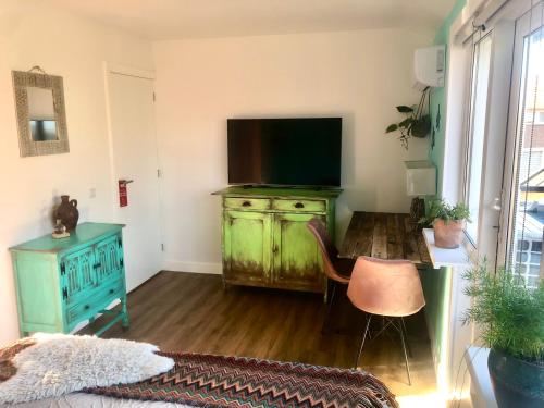 弗利辛恩Costa Linda B&B的客厅配有带电视的绿色梳妆台